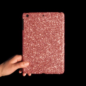 May include: A rose gold glitter tablet case. The case is made of a soft, flexible material and has a smooth, even finish.