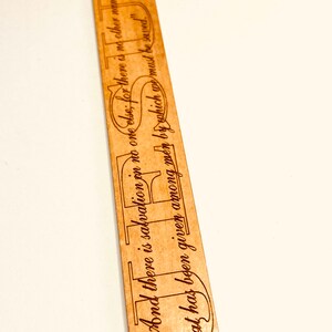 May include: A wooden bookmark with a red ribbon. The bookmark has the text "And there is salvation in no one else; for there is no other name under heaven by which we must be saved." Acts 4:12