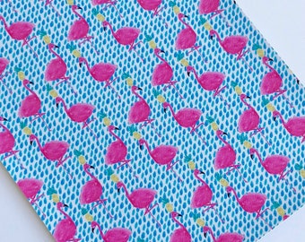 May include: Pink flamingo pattern fabric with a blue and white polka dot background. The fabric features a repeating pattern of pink flamingos with yellow pineapples.