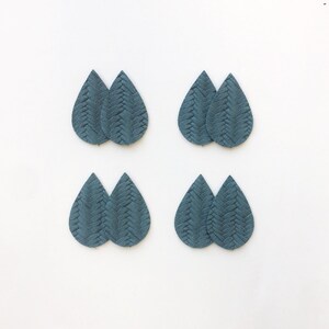 May include: Eight teal teardrop-shaped leather earring components. Each component has a woven texture. The components are arranged in pairs on a white background. These components are ideal for crafting earrings.