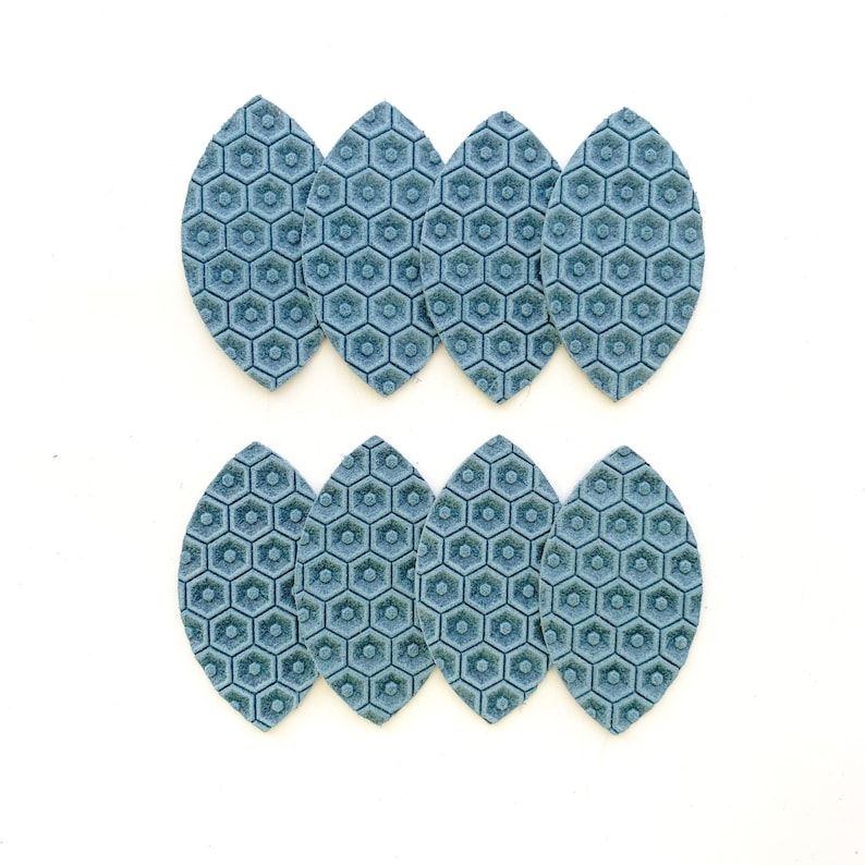 May include: Eight blue leather leaf-shaped earring blanks with a hexagonal pattern.