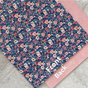 May include: A sheet of blue faux leather with a pink and white floral pattern. The back side of the sheet is a solid pink color. The words "Front" and "Back" are written on the sheet.