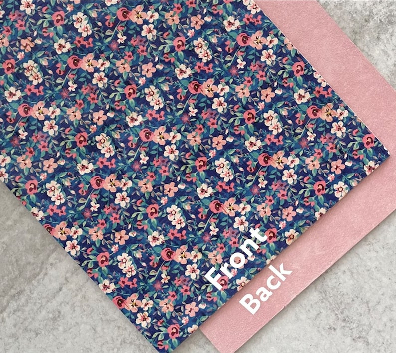 May include: A sheet of blue faux leather with a pink and white floral pattern. The back side of the sheet is a solid pink color. The words "Front" and "Back" are written on the sheet.