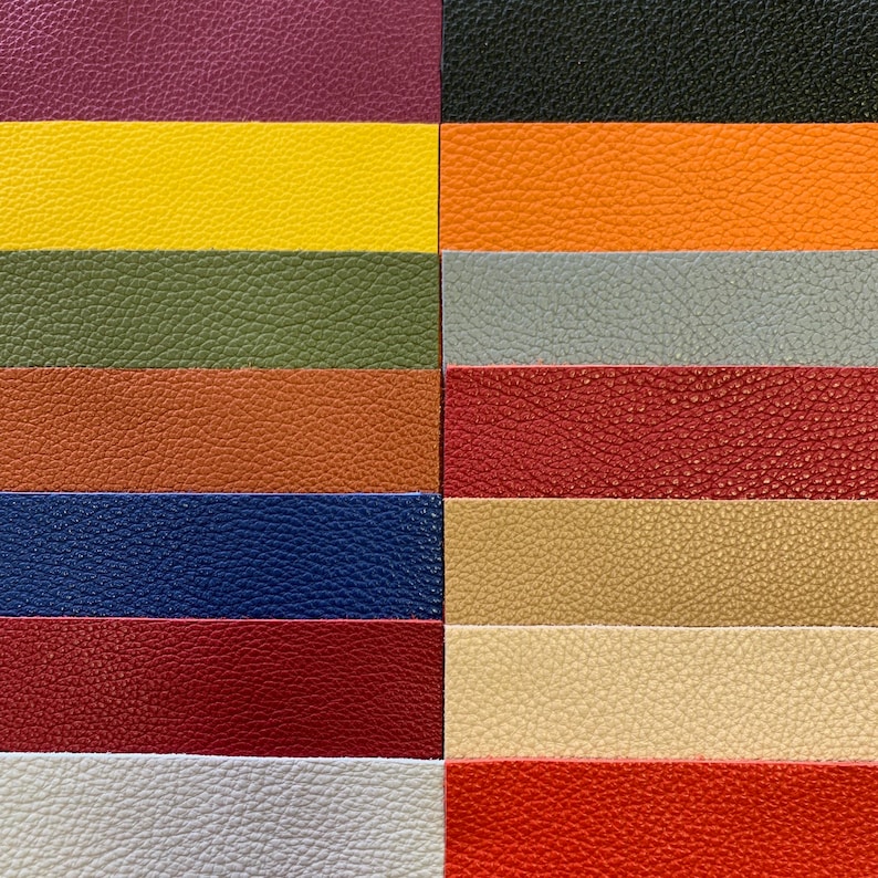 May include: A collection of 10 different colored leather swatches. The swatches are arranged in two rows of five, with each swatch being a different color. The colors are: purple, yellow, green, brown, blue, red, beige, cream, gray, and orange.