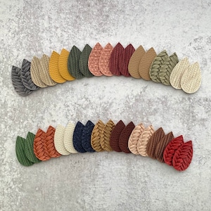 May include: A collection of 24 teardrop-shaped leather earrings in various colors and patterns, including brown, green, red, beige, and cream.