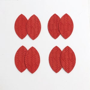May include: Set of six red leather earrings in a leaf shape with a woven pattern.