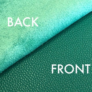 May include: Close-up of a piece of teal leather with a smooth, suede-like texture on the back and a textured, pebbled surface on the front. The words "BACK" and "FRONT" are printed on the leather.