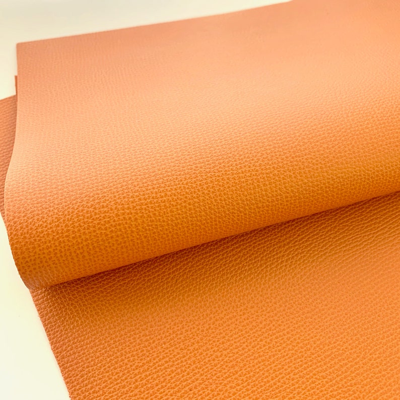 May include: A sheet of orange faux leather with a textured surface.