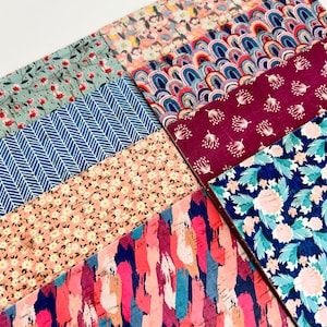 May include: A collection of patterned fabric squares in various colors and designs, including floral, geometric, and abstract patterns. The fabrics are arranged in a grid pattern, with each square showcasing a different design.