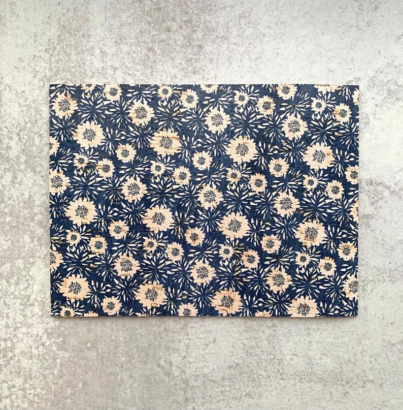 May include: A cork board with a blue and white floral pattern. The cork board is rectangular and has a natural cork texture.