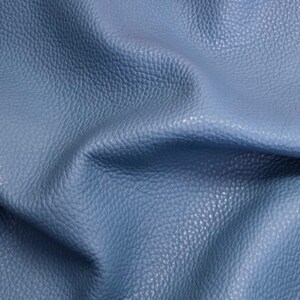 May include: Close-up of a textured blue leather fabric. The leather has a pebbled surface and a soft, supple feel.