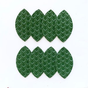 May include: Eight green leather leaves with a honeycomb pattern. The leaves are arranged in two rows of four.