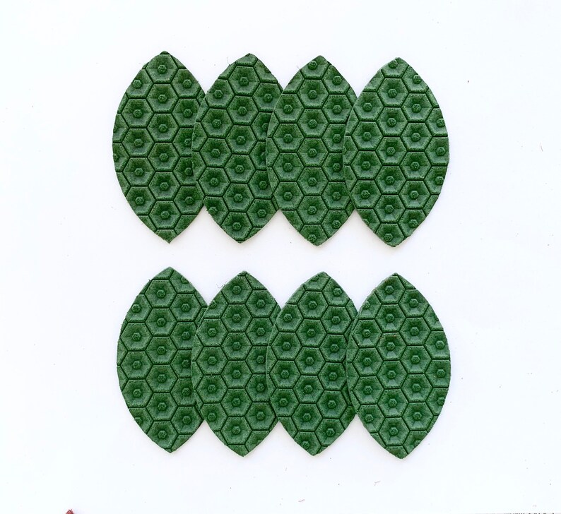 May include: Eight green leather leaves with a honeycomb pattern. The leaves are arranged in two rows of four.