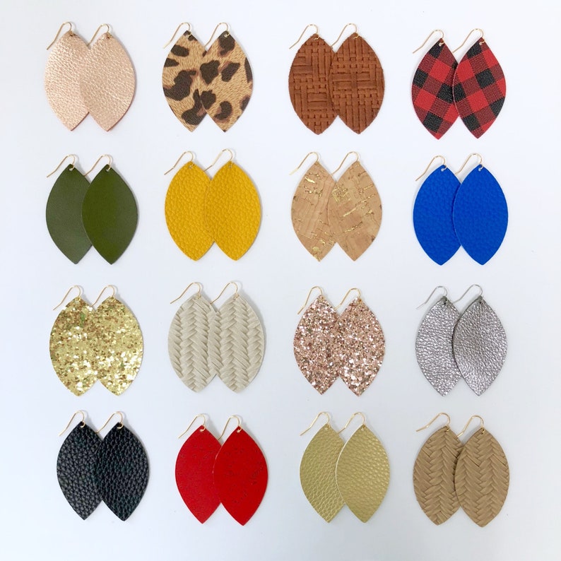 May include: Assortment of 15 pairs of leather earrings in various colours and patterns, including leopard print, plaid, glitter, cork, and solid colours. The earrings are all in the shape of a teardrop.