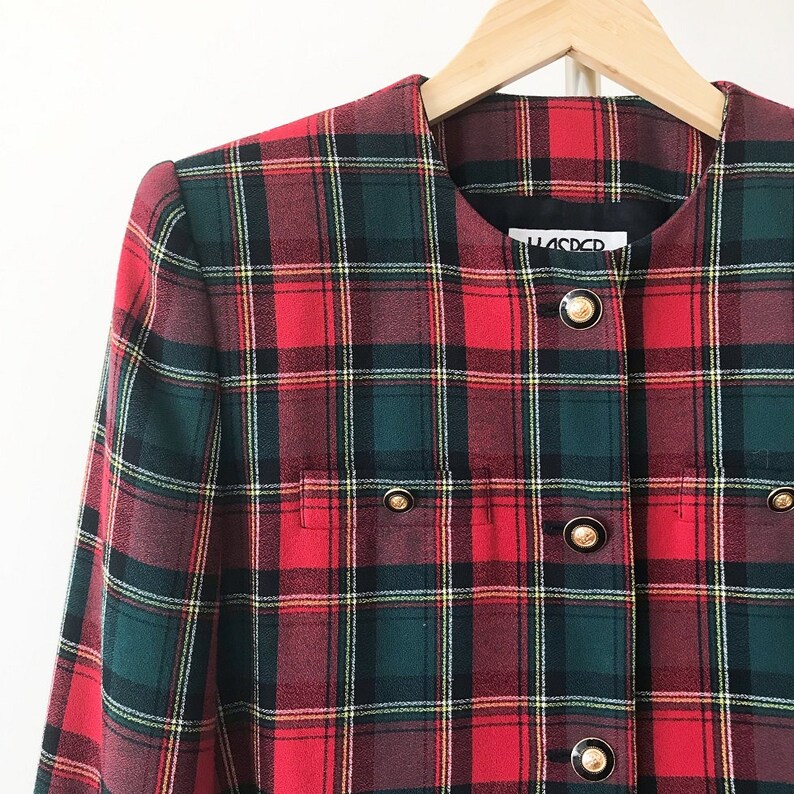 Puede incluir: Blazer de cuadros rojos, verdes y blancos con botones dorados. La etiqueta dice "H.A.D.C.R."