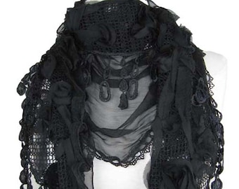 May include: Black lace scarf with a delicate floral design and dangling beads. The scarf is made of a sheer fabric and has a ruffled edge.