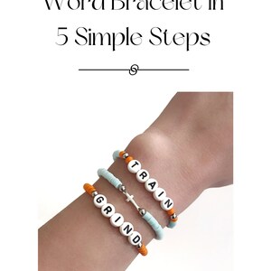May include: Two beaded bracelets on a wrist. One bracelet spells "GRIND" in white letters on orange beads. The other bracelet spells "TRAIN" in white letters on light blue beads. A small silver cross charm hangs between the bracelets.