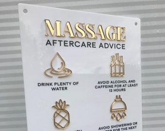 Könnte beinhalten: Ein weißes Schild mit goldenen Buchstaben, auf dem "Massage Aftercare Advice" steht. Das Schild hat sechs goldene Symbole mit Anweisungen für die Nachsorge, darunter Wasser trinken, Alkohol und Koffein vermeiden, leicht essen, Duschen vermeiden, aktive Aktivitäten vermeiden und einen Folgetermin vereinbaren.