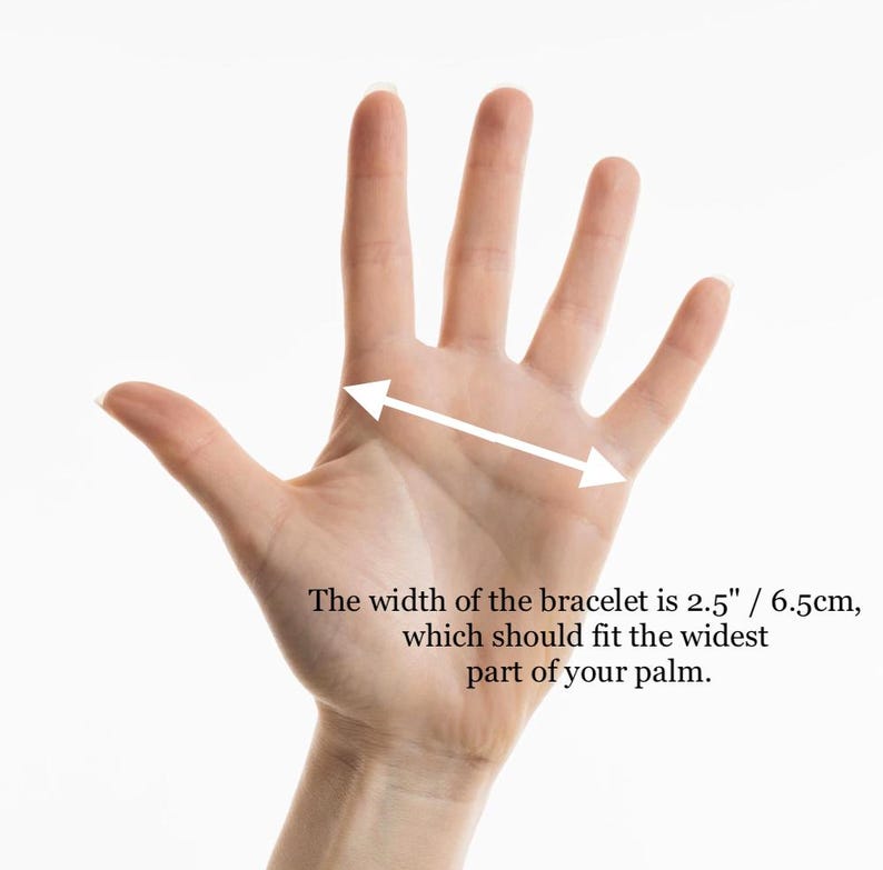 May include: A hand with a white arrow indicating the width of a bracelet. The text states the width is 2.5 inches / 6.5cm, which should fit the widest part of your palm.