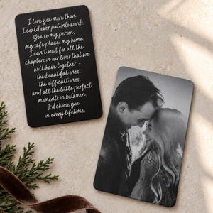 May include: Two rectangular metal wallet cards with rounded corners. One card features white cursive text on a black background reading I love you more than I could ever put into words. The second card displays a black and white photograph of a couple.