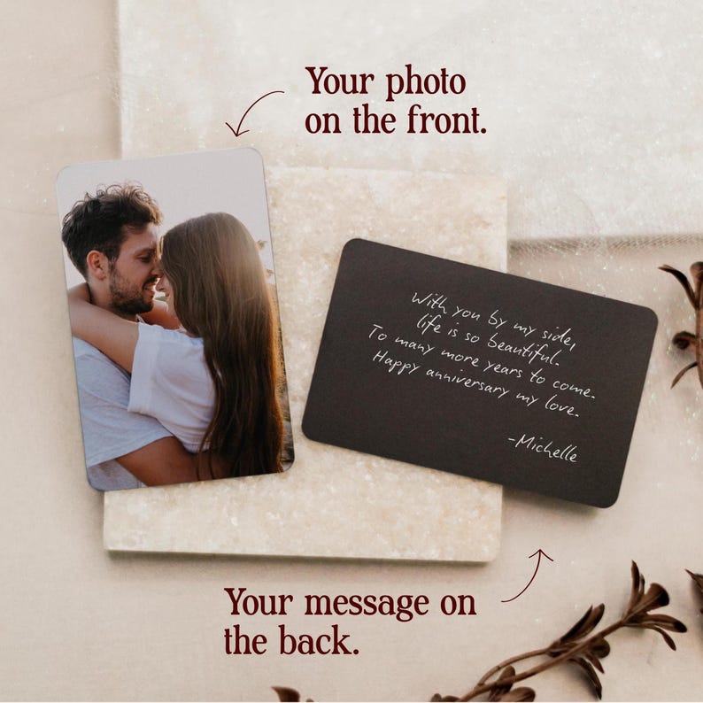 May include: A rectangular metal card featuring a color photograph of a couple embracing on the front and a black side with white handwritten text that reads: With you by my side, life is so beautiful. To many more years to come. Happy anniversary my love. -Michelle.