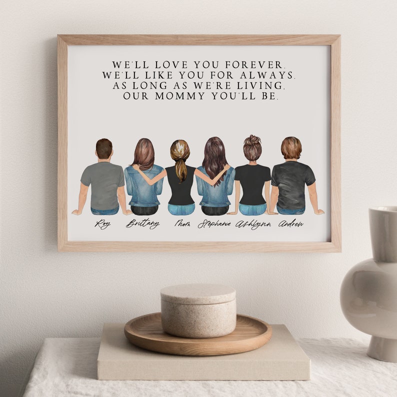 May include: A framed print with a white background and black text that reads "We'll love you forever. We'll like you for always. As long as we're living. Our mommy you'll be."  Below the text are six illustrated figures of people standing with their backs to the viewer. The figures are labeled "Ray", "Brittany", "Thom", "Stephane", "Ashlynn", and "Andrew".