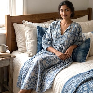 Może przedstawiać: Biały ceramiczny kubek z czarnym uchwytem i napisem "But First, Coffee" czarną, odręczną czcionką. Kubek stoi na białej powierzchni.