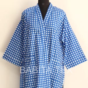 May include: A blue and white checkered robe with a V-neck and long sleeves. The robe is displayed on a mannequin. The robe has a matching belt. The text "BABITA TEX" is visible on the robe.