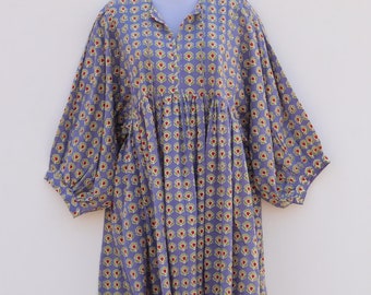 May include: A purple dress with a floral print featuring yellow and red flowers. The dress has a v-neck and 3/4 sleeves.
