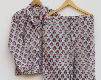May include: A gray and white pajama set with a pink floral print. The set includes a long-sleeved shirt with a button-up front and matching pants.