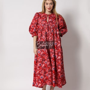 Puede incluir: Un vestido maxi rojo con estampado floral. El vestido tiene un escote redondo y mangas 3/4. El vestido est&aacute; hecho de algod&oacute;n y es perfecto para el verano.