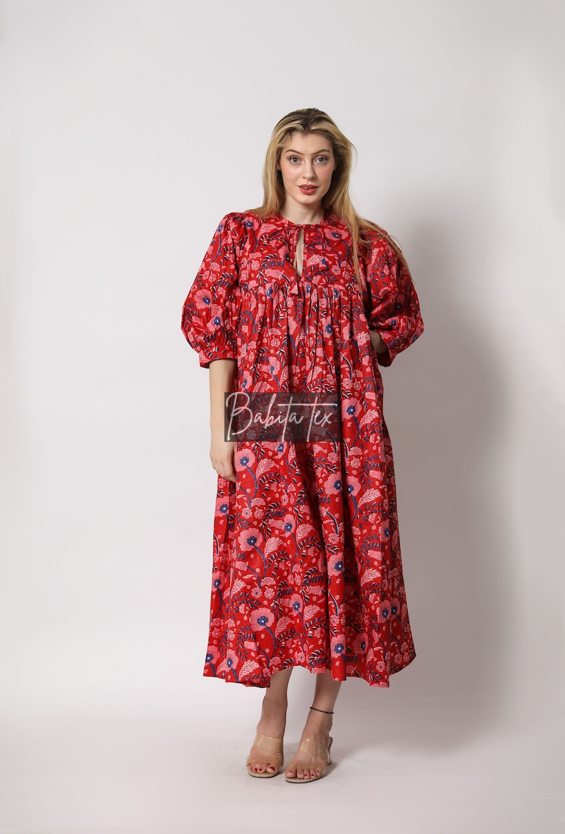 Puede incluir: Un vestido maxi rojo con estampado floral. El vestido tiene un escote redondo y mangas 3/4. El vestido est&aacute; hecho de algod&oacute;n y es perfecto para el verano.