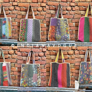 以下が含まれることがあります： 布製の持ち手付きのカラフルなパッチワークトートバッグが10個。バッグは赤、緑、青、黄、紫など、さまざまな生地と色で作られています。バッグはすべてレンガの壁に並べてあります。