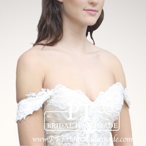 Puede incluir: Primer plano de un vestido de novia blanco de hombros descubiertos con detalles de encaje. El vestido tiene un escote de corazón y un corpiño ajustado. El texto "BRIDAL HANDMADE" y "www.PTBridalHandmade.com" es visible en el vestido.
