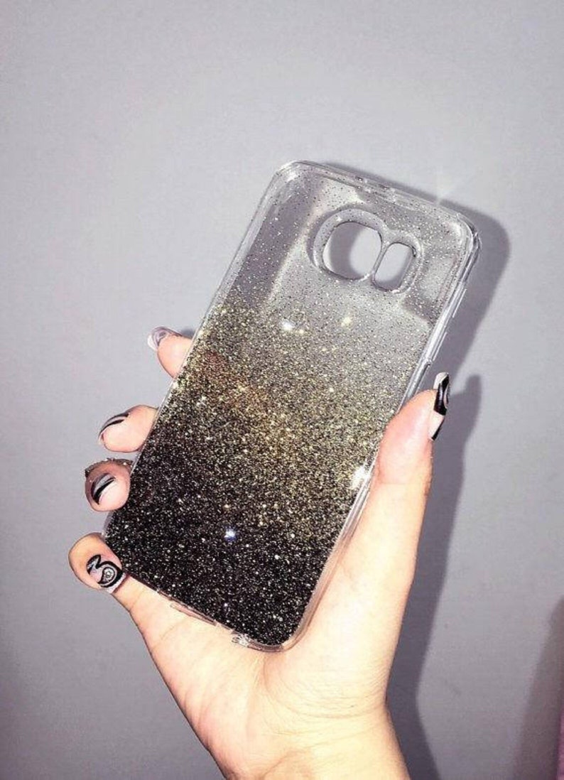 May include: A clear phone case with a black and gold glitter gradient. The glitter is loose and moves around inside the case.