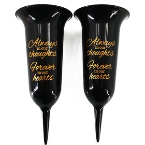 May include: Two black plastic flower vases with gold lettering. The vases have a pointed base and a wide opening. The text on the vases reads "Always in our thoughts Forever in our hearts".