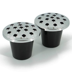 May include: Two silver metal flower vases with black plastic bases. Each vase has a circular top with multiple holes for holding flowers.