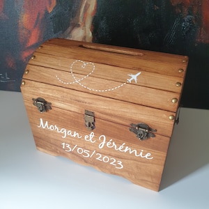 Könnte beinhalten: Holzkiste mit Herz- und Flugzeugdesign, personalisiert mit den Namen "Morgan et Jérémie" und dem Datum "13/05/2023".
