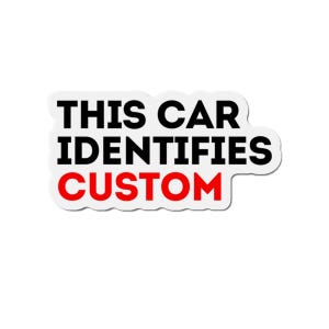 May include: A white sticker with the text "THIS CAR IDENTIFIES CUSTOM" in black and red block letters. The sticker has a white border and is designed to be applied to a car.