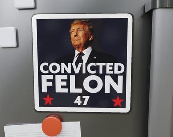 May include: A white square magnet with a photo of a man with blonde hair and a dark suit. The text "CONVICTED FELON 47" is printed in white on a red star background.