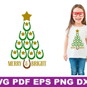 May include: Green and gold Christmas tree design with the text "Merry & Bright" made of horseshoes. The design is on a white t-shirt.