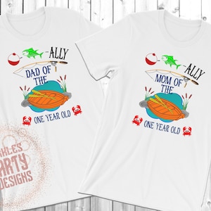 May include: Two white t-shirts with a fishing theme. The text on the shirts reads "Dad of the" and "Mom of the" with the name "Ally" and "One Year Old".