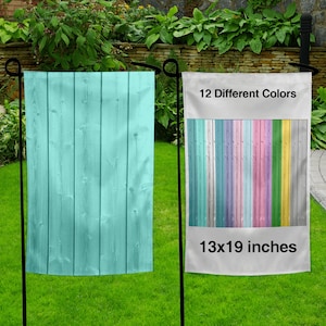 May include: Two garden flags with a wood plank design. The flag on the left is a solid light blue color. The flag on the right has 12 different colored planks and the text "12 Different Colors" and "13x19 inches".