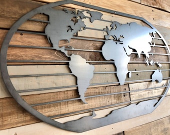 May include: A metal world map wall decor with a rustic wood background. The map is cut out in a circular shape and has a distressed finish.