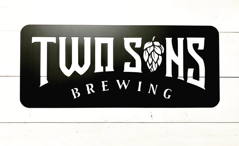 May include: Black metal sign with white lettering that reads "Twosons Brewing" with a stylized hop cone graphic.