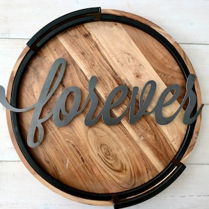 May include: A round wooden tray with a black metal rim and the word "forever" in a stylized font.