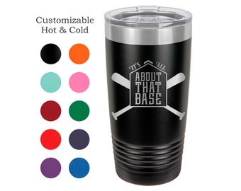 May include: Black stainless steel tumbler with a silver lid. The tumbler has a white engraved design that says "It's All About That Base" with two crossed baseball bats.