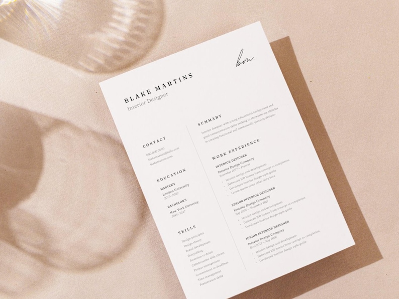 May include: A resume for Blake Martins, Interior Designer, printed on white paper. The resume includes sections for contact information, education, skills, summary, and work experience. The background is a light beige color.