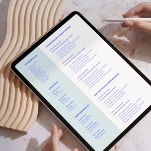 May include: A close-up of a tablet screen displaying a CV with sections for Programs, Awards, Experience Continued, Volunteer Experience, and References. The text is in blue and the background is light blue.
