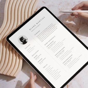Op de afbeelding: Een digitale tablet waarop een cv voor Blake Martins, een interieurontwerper, wordt weergegeven. Het cv bevat secties voor samenvatting, contact, opleiding, werkervaring en vaardigheden.